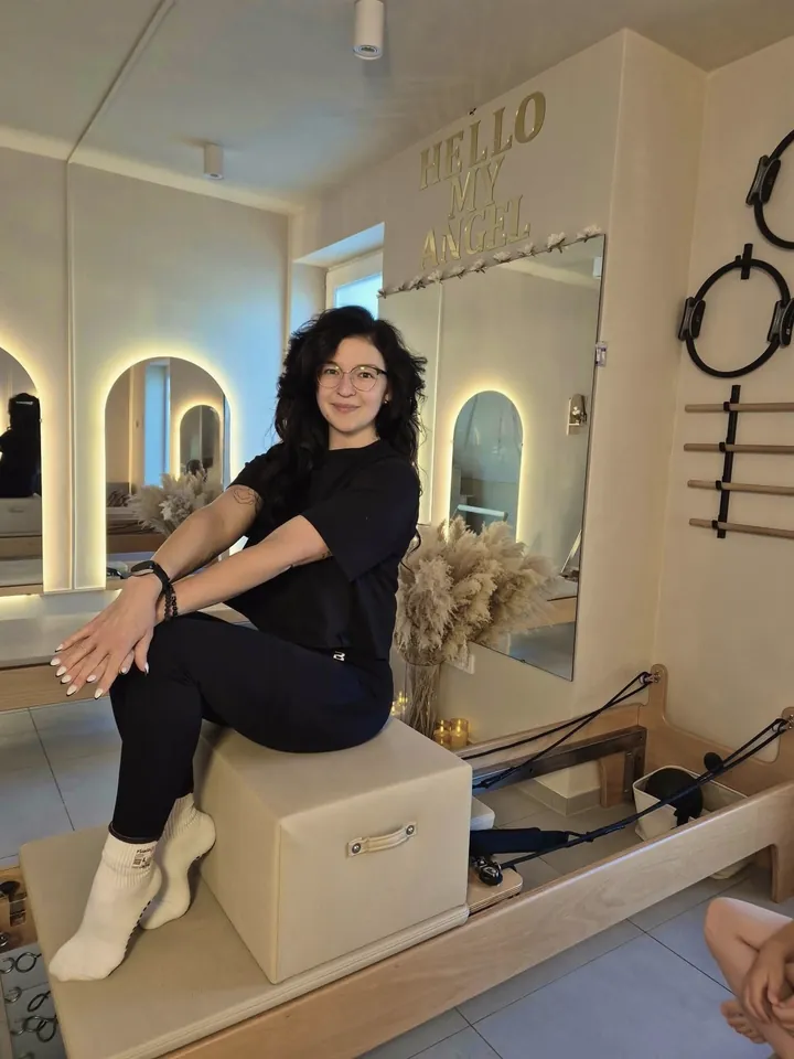 Réka, a Heaven Pilates Studio oktatója a reformer dobozán ülve